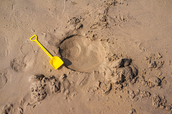 A children's spade on sandy beach