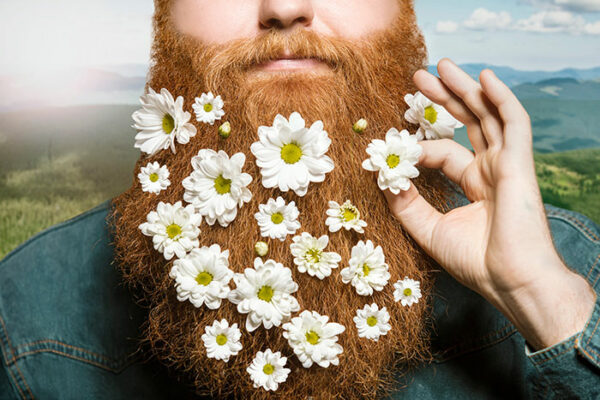 A man with a long red beard with daisies in it