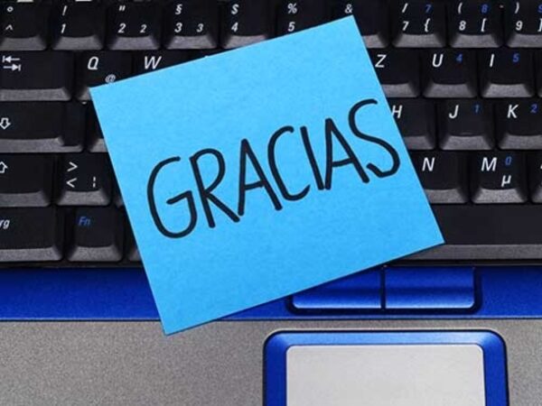 keyboard with a post-it note with GRACIAS written on it